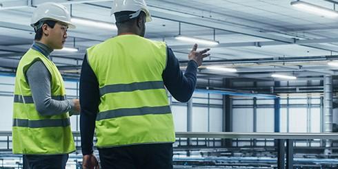 Two men overlooking a data center having a conversation
